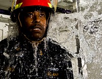 U.S. Navy Chief Damage Controlman Gregory Hightower demonstrates how to perform damage control procedures while inside a flooded compartment Jan. 5, 2010 at the Center of Naval Engineering Learning Site in Pearl Harbor, Hawaii.