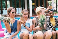Group of diverse women holding pineapple together