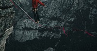 Male tightrope walker on a rope between the cliffs