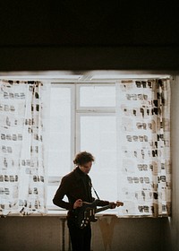 Man playing a guitar in his room