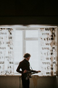 Man playing a guitar in his room