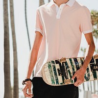 Young adult skater holding a skateboard in Venice Beach, Los Angeles