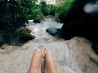 Girl sitting in a waterfall