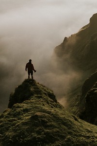 Man standing on a misty cliff background