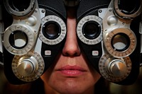 U.S. Air Force Master Sgt. Gennifer Sauter, a debts remissions branch chief with the Air Force Financial Service Center, looks through a phoropter during her pre-retirement eye exam at Ellsworth Air Force Base, S.D., April 7, 2010.