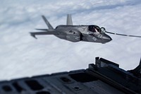 A U.S. Marine Corps F-35B Lightning II attack jet flies alongside a KC-130J tanker aircraft attached to a refueling drogue during an aerial refueling mission above the East China Sea, Oct. 23, 2018.
