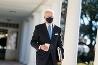 President Joe Biden walks with a cup of coffee Tuesday, March 2, 2021, along the Colonnade of the White House to the Oval Office.