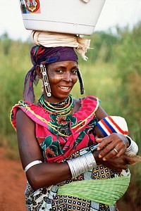A Beninois woman returns from getting water with her baby. Original public domain image from <a href="https://www.flickr.com/photos/peacecorps/5405374039/" target="_blank">Flickr</a>