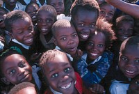 South African children huddled together and smile for a photo taken by a Peace Corps Volunteer. Original public domain image from Flickr