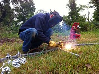 Anchoring the log boom at Roush LakeHuntington, Ind. — DJ Unger uses a cutting torch to cut a cable used in anchoring the log boom at J. Edward Roush Lake, June 1, 2012. (U.S. Army Corps of Engineers photo by Jared Perrott). Original public domain image from Flickr