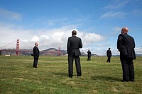 President Barack Obama stands with U.S. Secret Service agents and looks at the Golden Gate Bridge, prior to boarding Marine One at the Crissy Field landing zone for departure from San Francisco, Calif.
