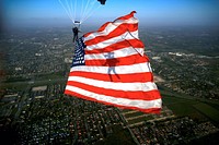 160226-N-IQ655-172 HOMESTEAD, Fla. (Feb. 26, 2016) - Special Warfare Operator 1st Class Trevor Thompson, member of the U.S. Navy Parachute Team "The Leap Frogs," presents the American flag during a training demonstration at Homestead Air Reserve Base. The Leap Frogs are in Florida preparing for the 2016 show season.