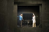 Alliston Watts and Andrew Mani mount a PV module for IV performance testing in Fraunhofer CSE&rsquo;s solar simulator dark tunnel. Original public domain image from Flickr