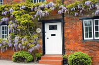 Brick house with purple flowers. Free public domain CC0 image.