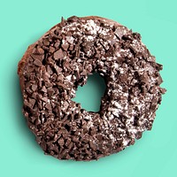 Shredded chocolate ring donut on turquoise background, food photography