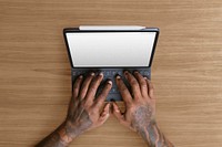 Tattooed man using tablet keyboard