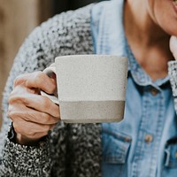 Woman holding white coffee mug