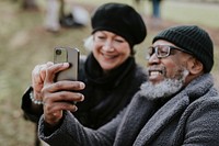 Diverse couple taking selfie in the park 