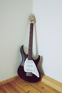 Musical instrument electric guitar leaning on the wall