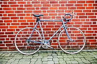 Vintage bike resting against a brick wall