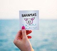 Woman holding note with summer graphic at the beach