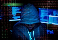 Hacker in a hoody with computer background