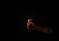 Hand holding lighter in the dark