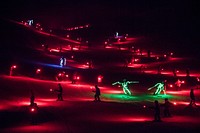 Colorfully attired skiers and snowboarders carrying flares and LED (light-emitting-diode) lights descend Howelsen Hill en masse prior to a spectacular fireworks show — one of the largest in the United States — during the "Warmth of Winter" exhibition at the annual Winter Carnival in Steamboat Springs, Colorado.