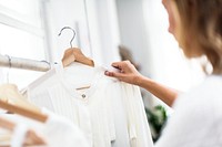 A stylish is choosing cloth from the rack