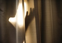 Human shadow behind a curtain