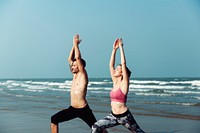 Couple doing yoga by the beach