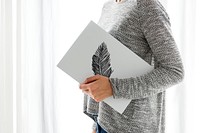 Woman holding a board with a feather drawing