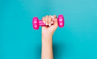 Closeup of hand holding a pink dumbbell