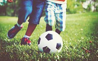 Kids playing football on a grass