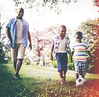 Happy African family father and son playing football together