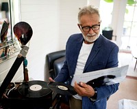 An elderly man playing a record
