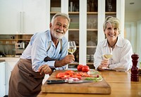 Senior couple enjoying white wine in the kitchen