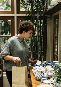 Woman choosing some pottery products for decoration
