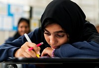 Young Muslim student studying in a class