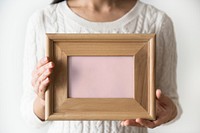 A woman holding blank wooden picture frame