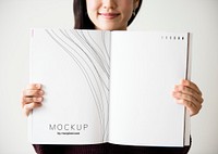 Happy woman holding up a textbook mockup