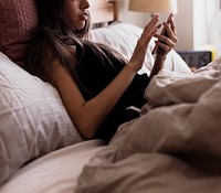 Woman using her phone in bed