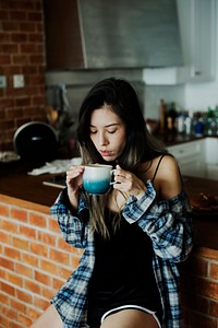 Girl drinking coffee in the kitchen