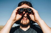 Young traveler man using a binoculars