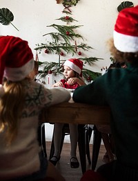 Kids at a table wearing Santa hats