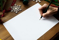 A person preparing to write a Christmas wishlist