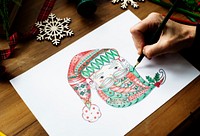 A person drawing a colorful Santa Claus&#39; face