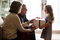 Little girl receiving a Christmas present from her parents
