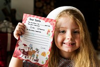 Little girl holding her Christmas wishlist