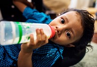 Young Indian boy drinking milk from bottle